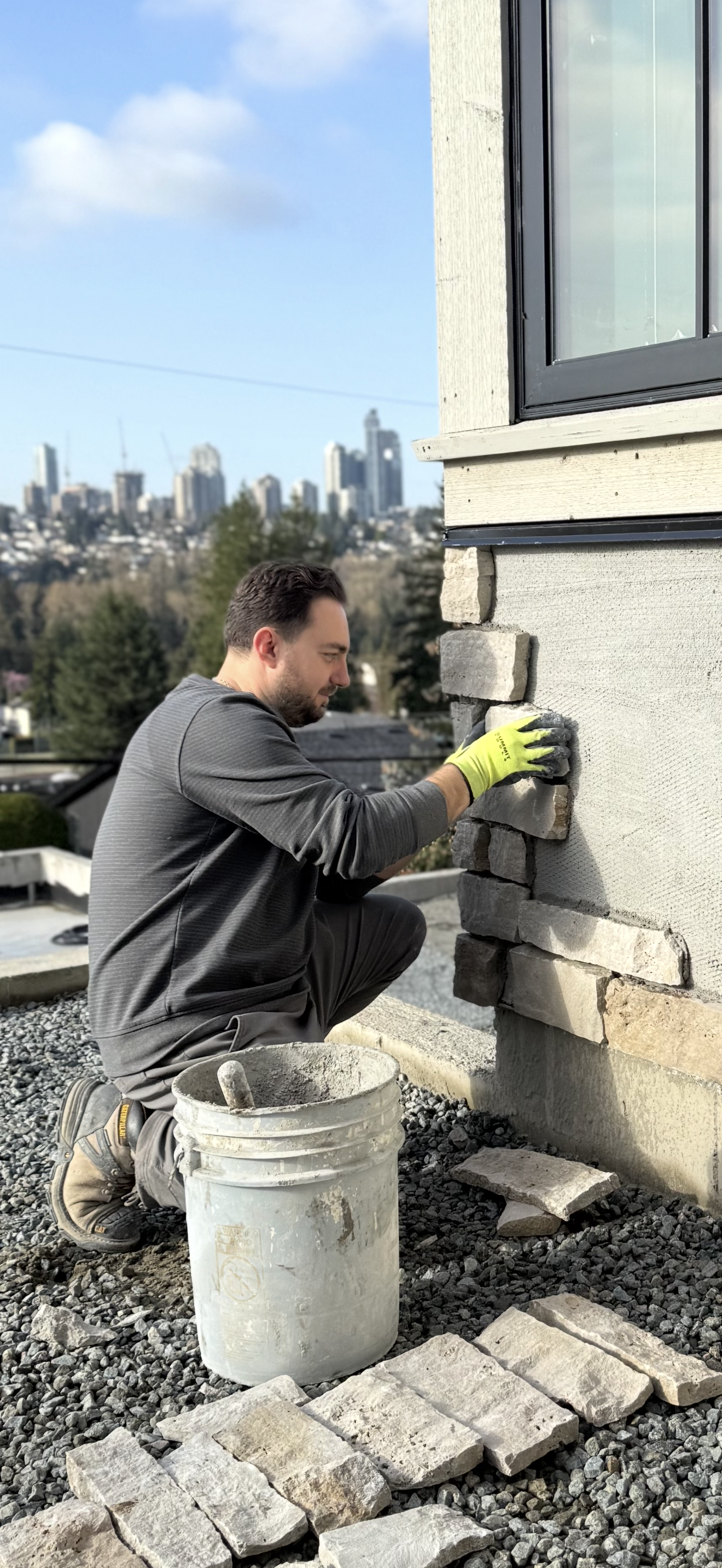 Leart hand-setting natural stone veneer on a job site